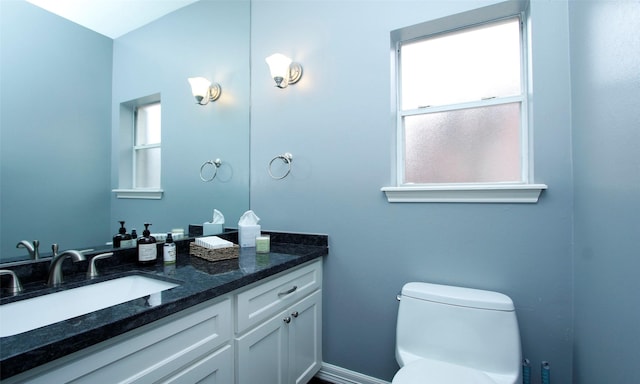 bathroom featuring baseboards, vanity, and toilet