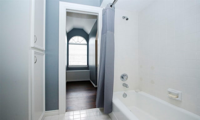 full bath with lofted ceiling, shower / bath combo, and tile patterned floors