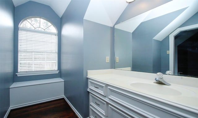 bathroom with vaulted ceiling, wood finished floors, and vanity