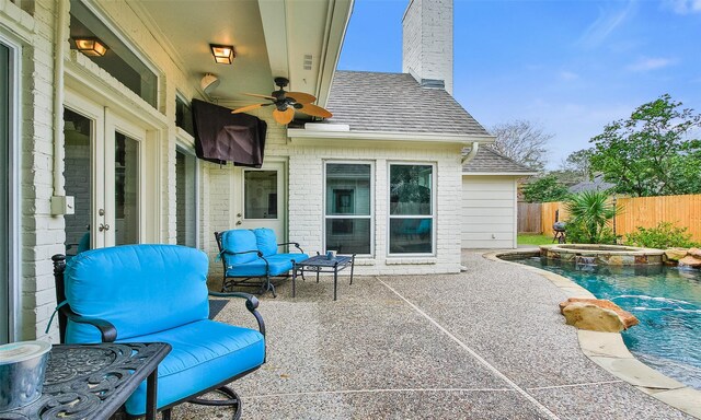 view of patio with a pool with connected hot tub, ceiling fan, and fence