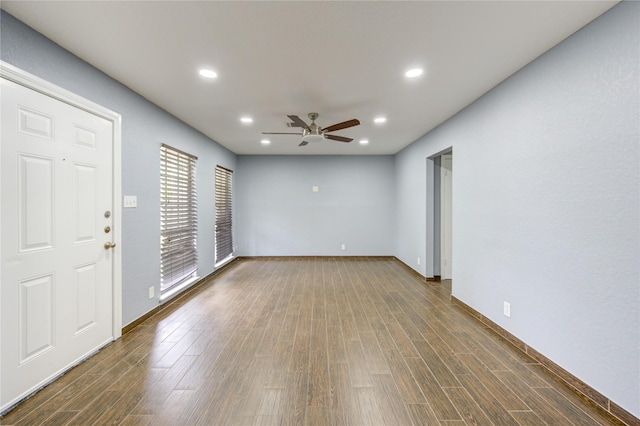 empty room with a ceiling fan, recessed lighting, dark wood-style flooring, and baseboards