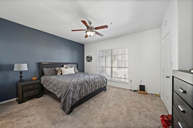 bedroom featuring light carpet, a ceiling fan, and baseboards