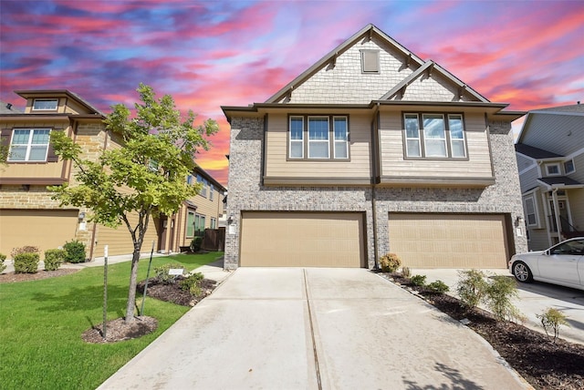 view of front of property featuring brick siding, a lawn, a garage, and driveway