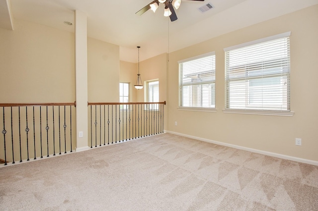 carpeted spare room featuring visible vents, baseboards, lofted ceiling, and ceiling fan