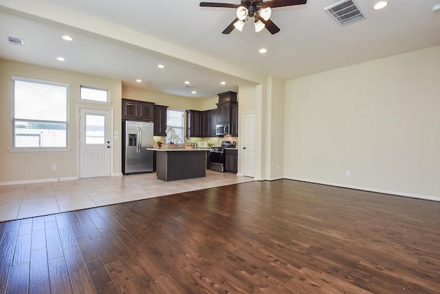 kitchen featuring visible vents, appliances with stainless steel finishes, open floor plan, and light wood-style flooring