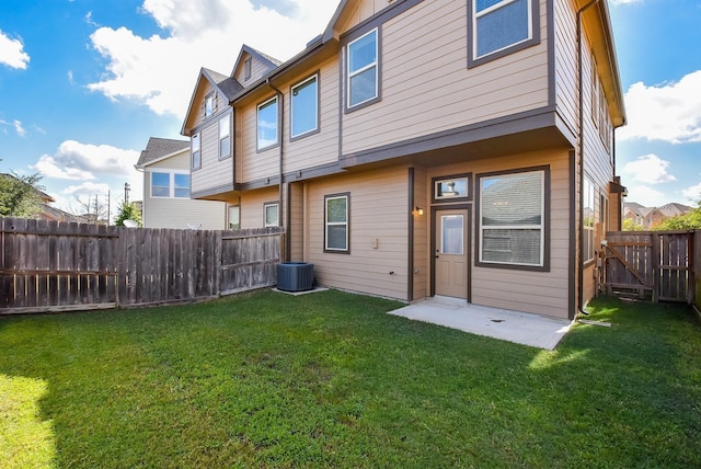 rear view of property featuring a lawn and a fenced backyard