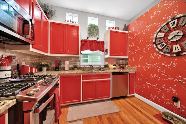 kitchen featuring appliances with stainless steel finishes, plenty of natural light, a sink, and wallpapered walls