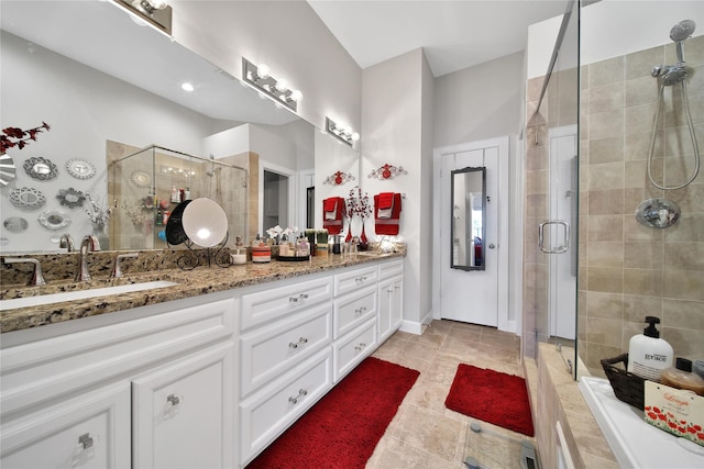 full bath with a sink, a shower stall, and double vanity