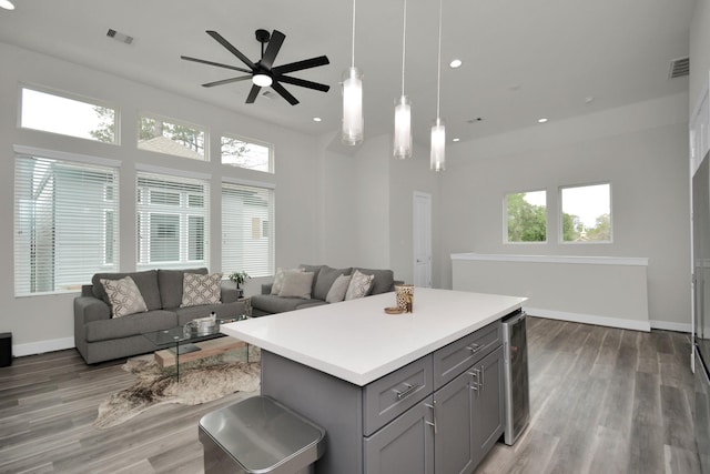 kitchen featuring open floor plan, wine cooler, visible vents, and gray cabinetry