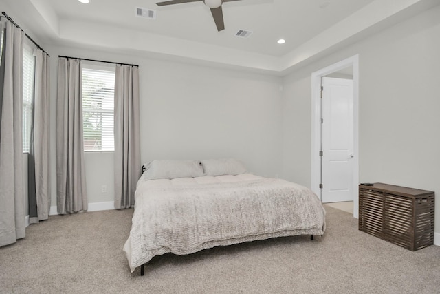 bedroom featuring carpet, visible vents, and a tray ceiling