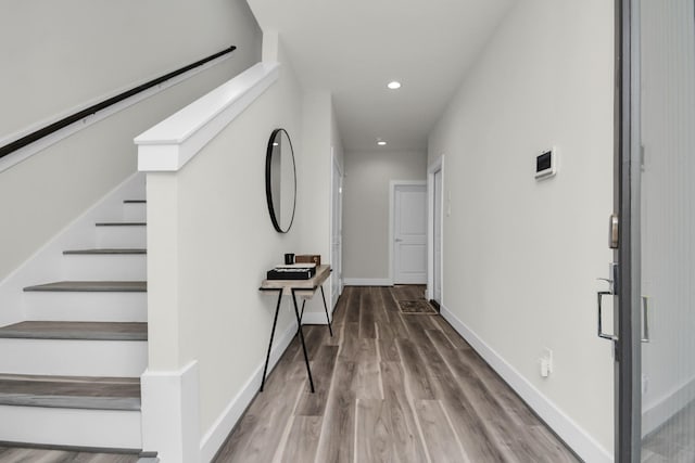 hallway featuring stairs, recessed lighting, wood finished floors, and baseboards