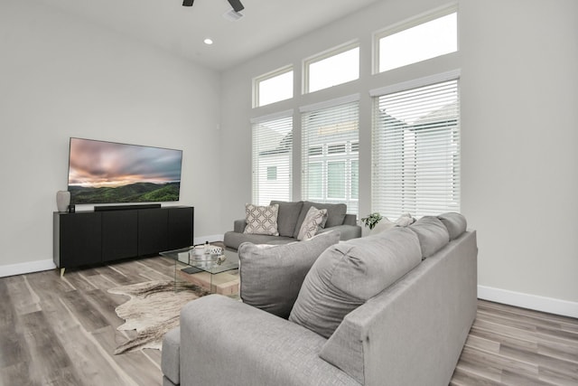 living area with ceiling fan, recessed lighting, light wood-style flooring, and baseboards