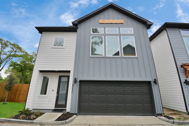 modern farmhouse featuring board and batten siding, fence, driveway, and an attached garage