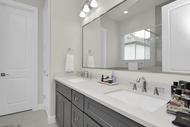 full bath featuring double vanity, a stall shower, a sink, and tile patterned floors