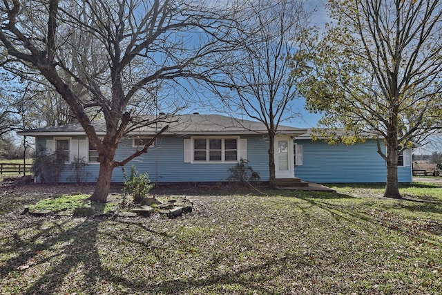 ranch-style home with entry steps and a front lawn