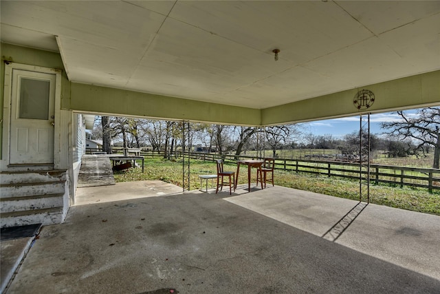 view of patio featuring a rural view and fence