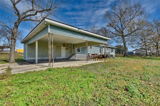 view of front of home featuring a carport, a front yard, fence, and driveway