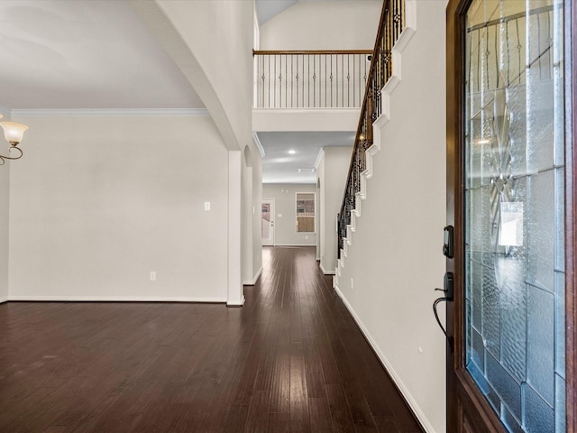 foyer entrance featuring baseboards, stairway, dark wood finished floors, and crown molding