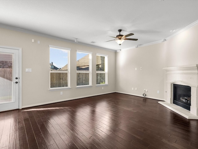 unfurnished living room with a fireplace with raised hearth, ornamental molding, wood-type flooring, and a ceiling fan