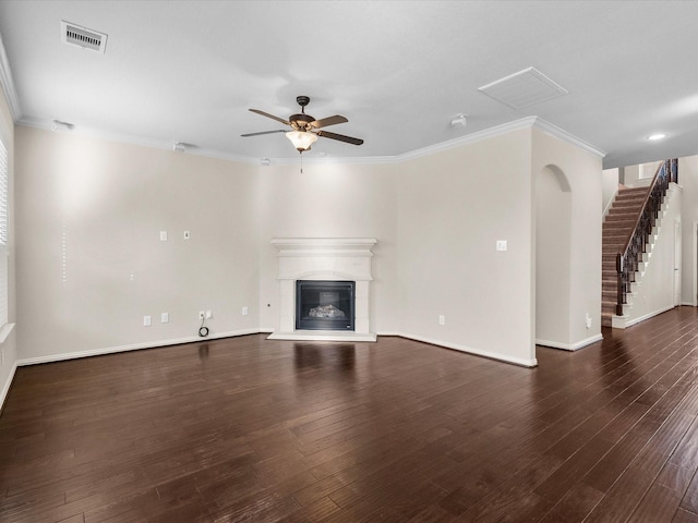 unfurnished living room featuring crown molding, visible vents, wood finished floors, and a glass covered fireplace