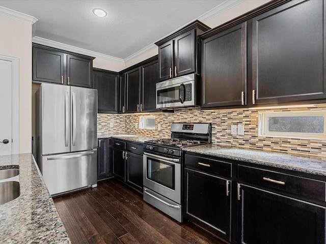 kitchen with appliances with stainless steel finishes, backsplash, dark wood-style flooring, and ornamental molding