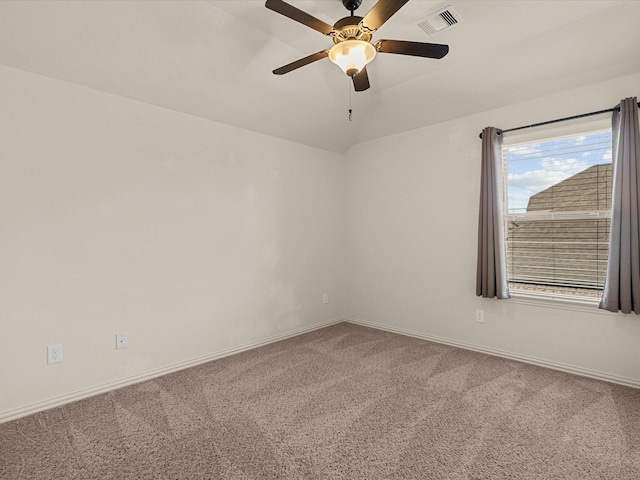 carpeted spare room with vaulted ceiling, ceiling fan, visible vents, and baseboards