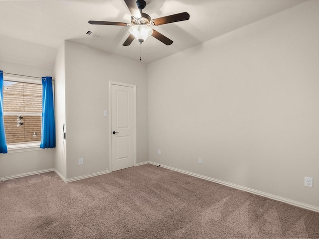 spare room with a ceiling fan, carpet, visible vents, and baseboards