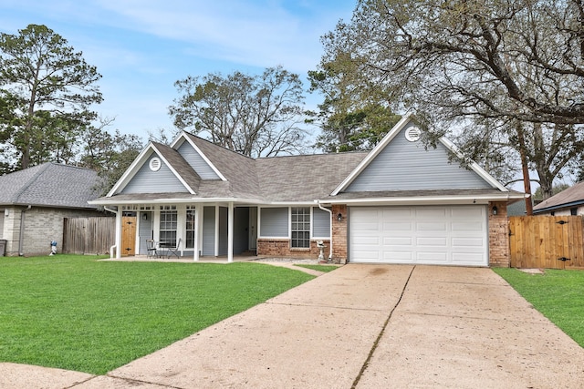 view of front of house with concrete driveway, brick siding, a front yard, and fence