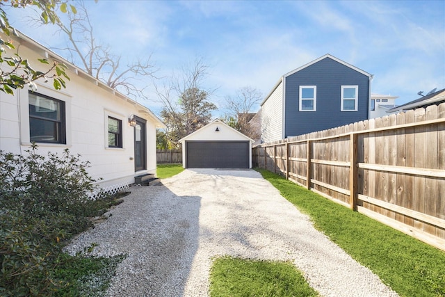 view of yard featuring a garage, an outdoor structure, and fence