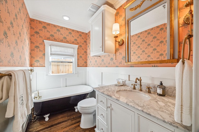 bathroom featuring a wainscoted wall, vanity, wood finished floors, a freestanding tub, and wallpapered walls