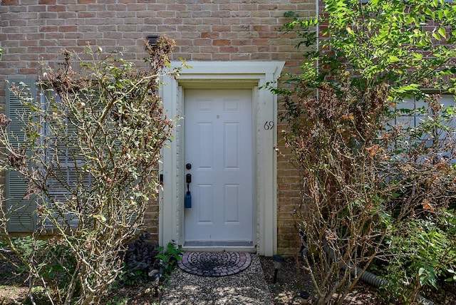 entrance to property featuring brick siding