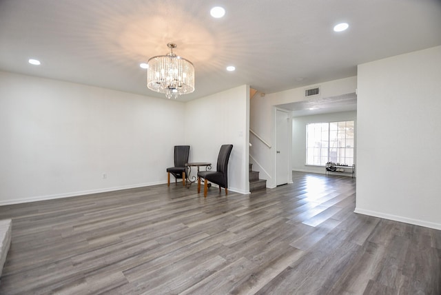 unfurnished room featuring baseboards, visible vents, stairway, wood finished floors, and recessed lighting