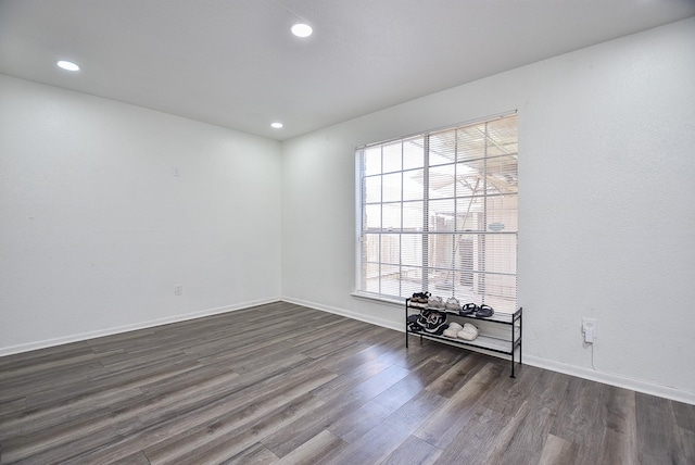 spare room with recessed lighting, dark wood finished floors, and baseboards