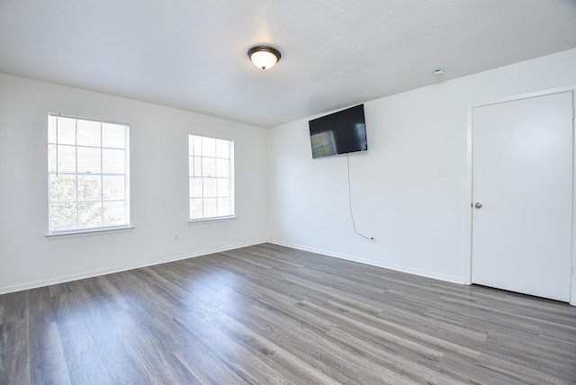 unfurnished room with baseboards and wood finished floors