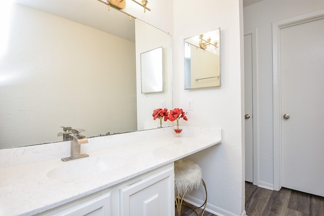 bathroom with wood finished floors, vanity, and baseboards