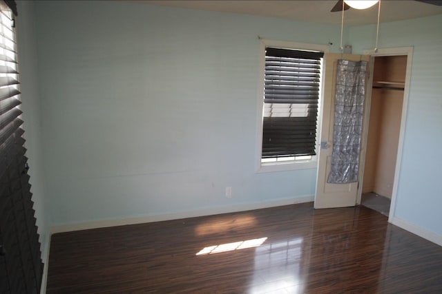 spare room featuring wood finished floors, a ceiling fan, and baseboards