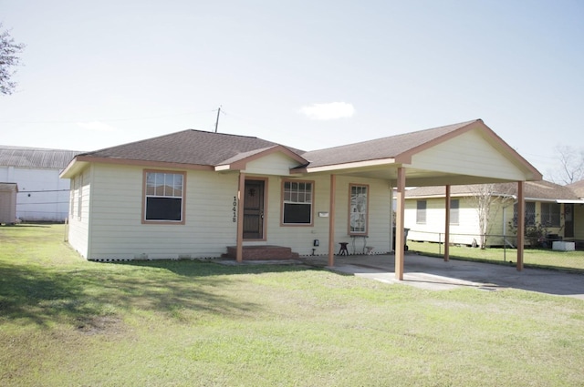 ranch-style home with driveway, roof with shingles, an attached carport, and a front yard