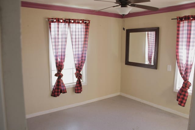 carpeted empty room with a ceiling fan and baseboards