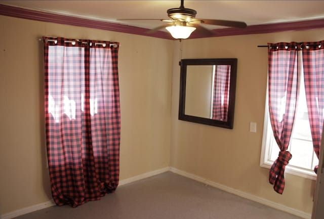 carpeted spare room with baseboards and a ceiling fan