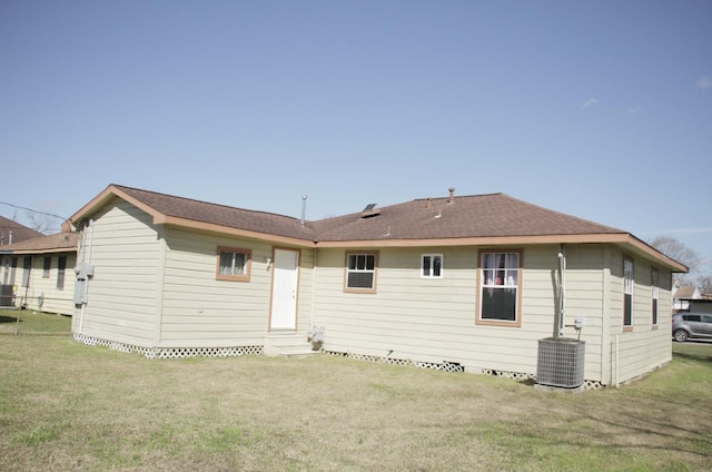 rear view of house featuring entry steps, a yard, and cooling unit