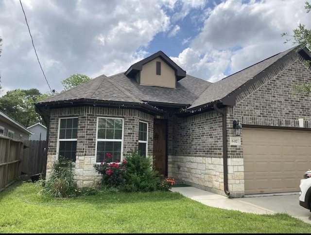 view of front of property with a garage, stone siding, brick siding, and roof with shingles