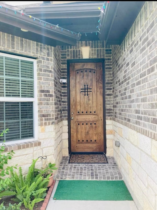 view of exterior entry featuring brick siding