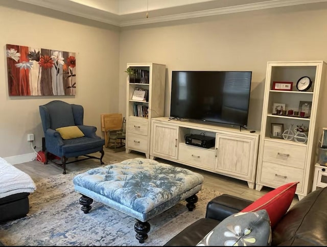 living area with crown molding, baseboards, and wood finished floors