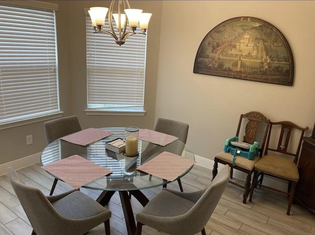 dining room with a chandelier, light wood-type flooring, and baseboards