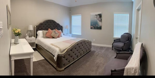 bedroom with lofted ceiling, carpet flooring, and baseboards