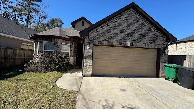 view of front of home with an attached garage, fence, concrete driveway, and brick siding