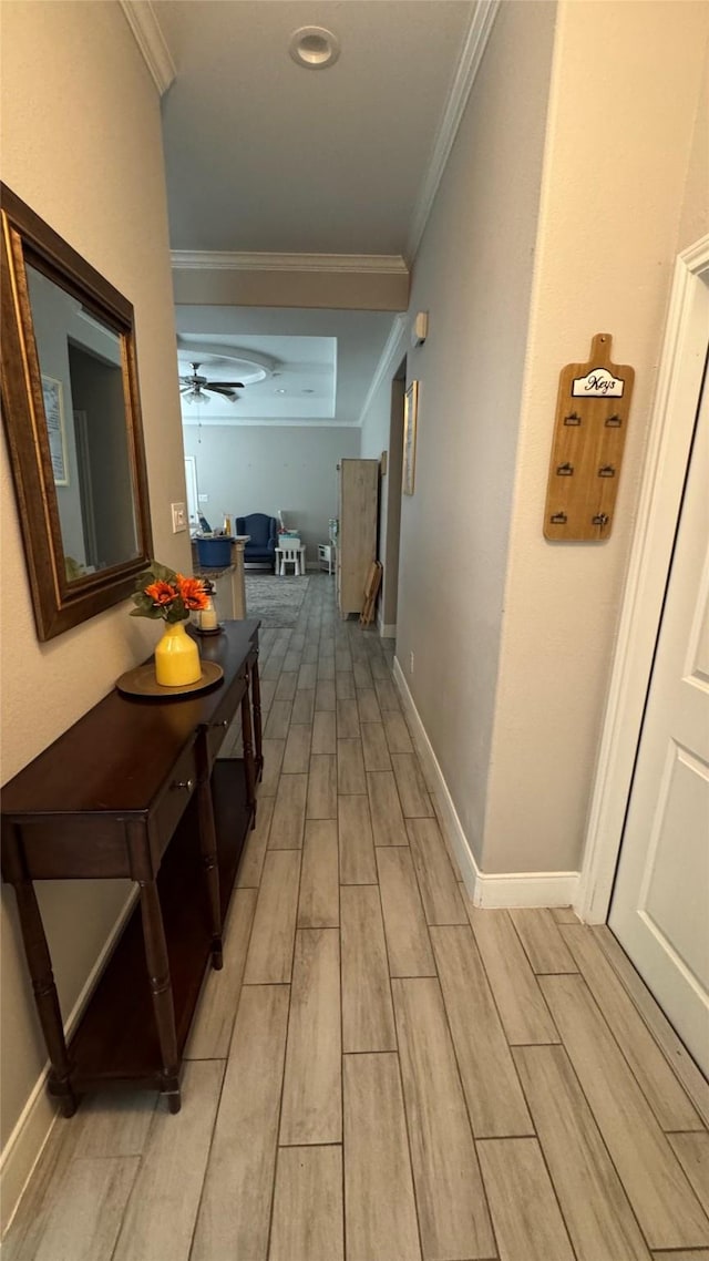 corridor with wood tiled floor, baseboards, and crown molding