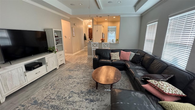 living area featuring light wood-style flooring, recessed lighting, baseboards, a tray ceiling, and crown molding