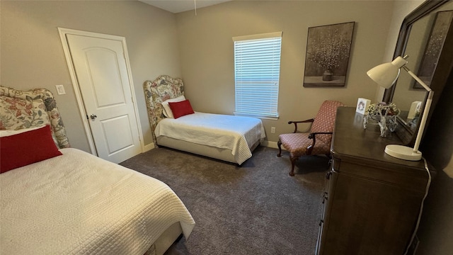 bedroom with dark colored carpet and baseboards