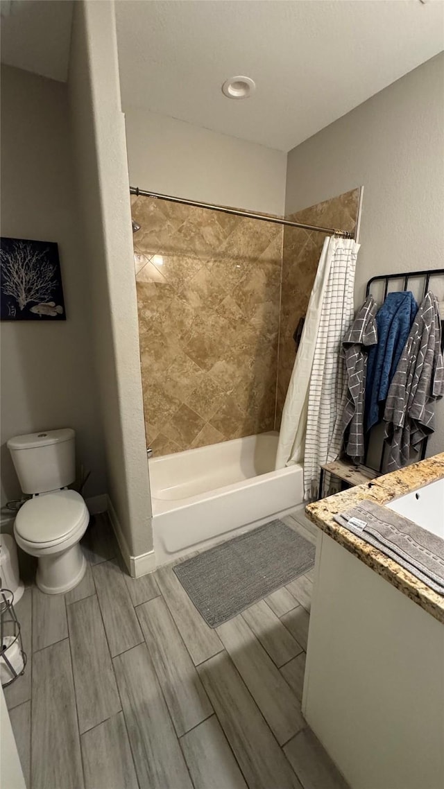 bathroom with baseboards, toilet, shower / tub combo with curtain, vanity, and wood finish floors